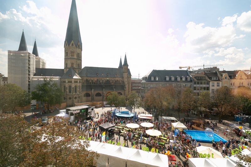 Fest mit vielen Menschen, Bühne und weißen Zelten auf dem Münsterplatz