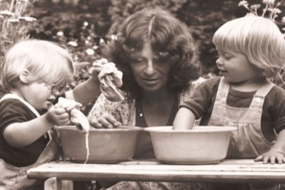 schwarz-weiß Fotografie mit einer Frau und zwei Kindern im Garten