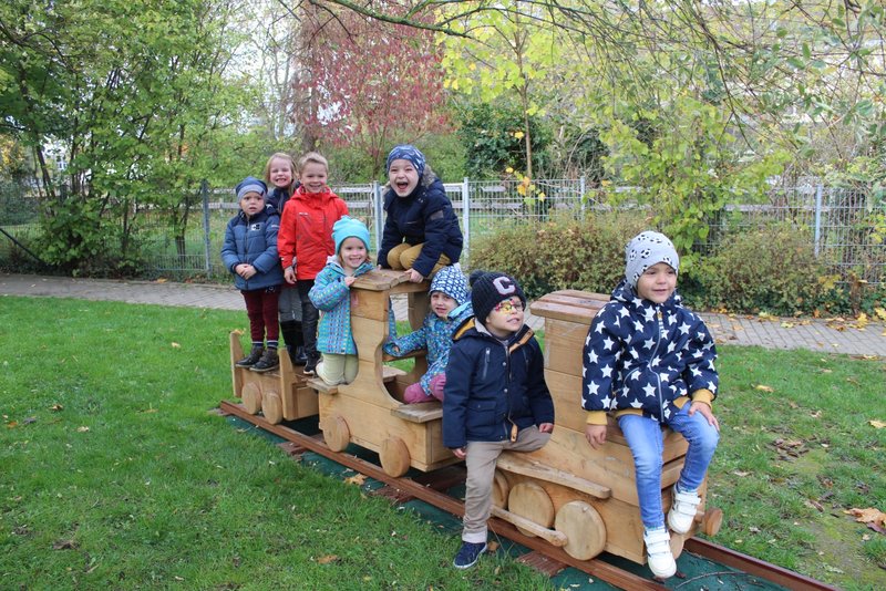 Eisenbahn Kita Rasselbande Kinder spielen auf einer Holz-Eisenbahn